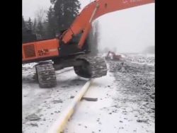 bagger klettert ueber ein rohr