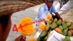 Eine Mango wird von einem Straßenhändler schön verziert eine mango wird von einem strass