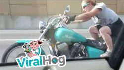 Frau singt und turnt auf dem Motorrad herum frau singt und turnt auf dem mot