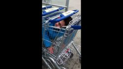 Junge wird in Einkaufswagen eingesperrt junge wird in einkaufswagen eing