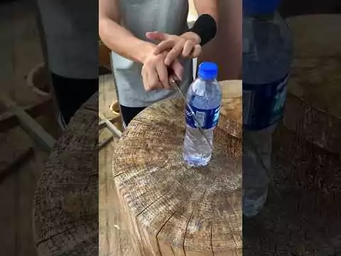 Scharfes Messer schneidet durch Wasserflasche durch messer wasser